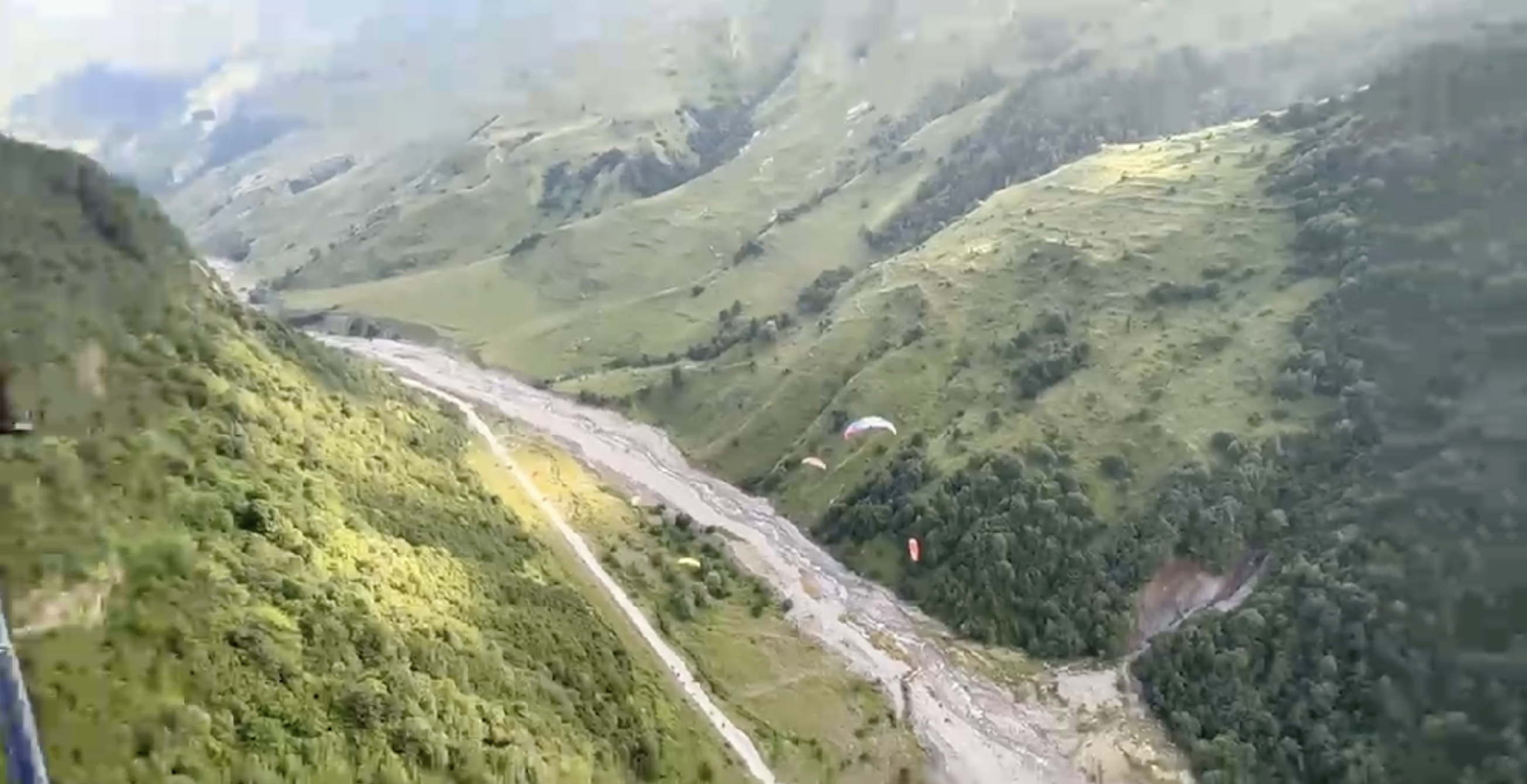 Tandem paraglider above the snowy Gudauri mountain ridge
